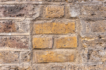 Brick wall with yellow, red, orange and gray colors.
