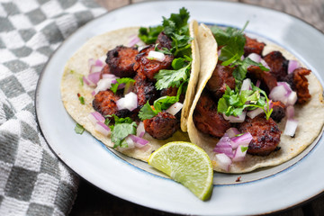 Mexican food: Delicious red chorizo tacos on wooden background