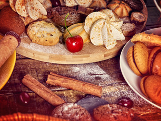 Oatmeal and nut cookies and sand biscuit on tier cake stand, crispy wafer rolls with cream on kitchen on wooden table in rustic natural style. Easily digestible and quickly digestible substances.