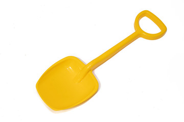 Yellow baby shovel on a white background. Plastic shovel. Toys for sand.