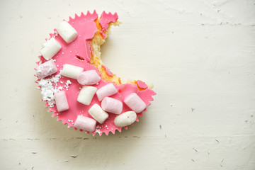 Cup Cake angebissen, rosa mit Marshmallow