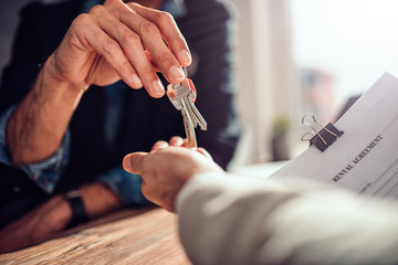 Real estate agent passing keys to his client - obrazy, fototapety, plakaty
