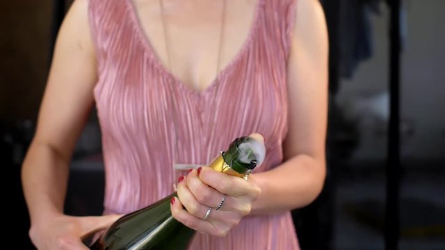Anonymous woman popping bottle of champagne in slow motion
