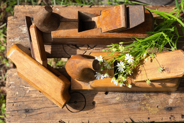 Antique Planes on the old board and a bouquet of flowers, top view, Retro hand tools. Traditional woodworking. Copy space