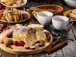 Cookies heart shape, sand rolled biscuit and cinnamon stick on wood table served dessert spoon at kitchen in rustic style. Morning sun flare. Cherry in powdered sugar.