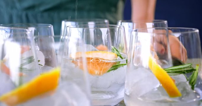 Woman making gin tonic cocktails at party