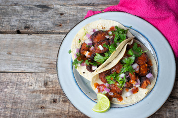 Mexican food: Delicious red chorizo tacos on wooden background