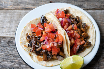 Vegan and vegetarian mexican mushrooms tacos with sauce and lime
