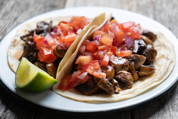 Vegan and vegetarian mexican mushrooms tacos with sauce and lime