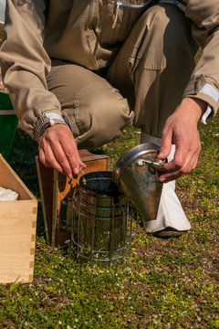 Hands Of Female Beekeeper Preparing Old Bee Smoker On Rooftop. Apiculture. Urban Beekeeping.