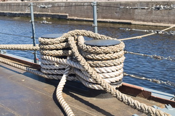 ropes stretch in all directions from the deck of a moored ship