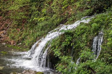 Beautiful view of natural waterfall with crystal clear water among green woods - 270492830