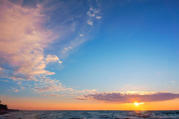 Obraz premium Sunset over the sea. Reflection of sunlight in the sea waves. The sky in the sunset rays.