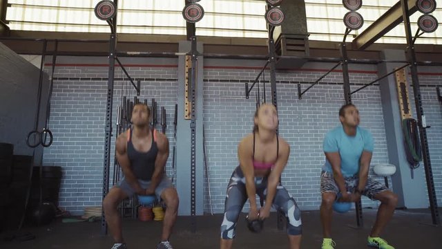 Muscular people exercising with kettlebells