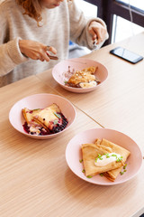 Woman is trying various of crepes in a fancy restaurant