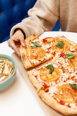 Having traditional italian pizza Margherita with tomato, cheese and tomato sauce topping on crispy dough for dinner
