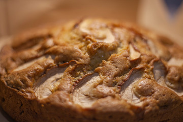 Homemade cake with apple. Homemade charlotte baked in the oven. Prikotovlenie cupcake for refreshments. Dessert for tea. Sweet cake made by turning to the table.