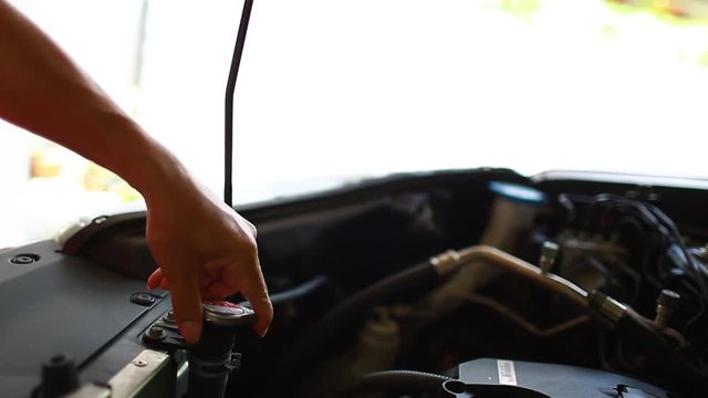 hands of mechanic check water in car radiator and add water to car radiator, service and maintenance of cars or vehicles, selective focus.