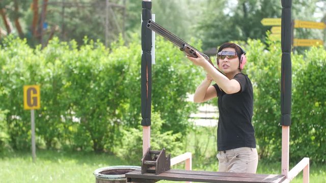 young beautiful girl shoots a flying target at an open shooting range,trap shooting