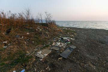 Garbage heaps on the sea beach. Pollution of the territory. Garbage dump on the beach.