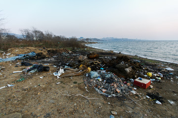 Fototapeta na wymiar Garbage heaps on the sea beach. Pollution of the territory. Garbage dump on the beach.