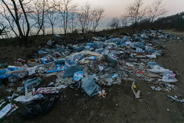 Garbage heaps on the sea beach. Pollution of the territory. Garbage dump on the beach.