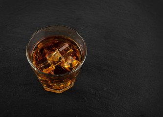 Iced Whiskey Glass on Natural Black Stone Background