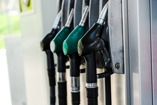 Selective Focus Of Green And Black Fuel Pumps At Gas Station