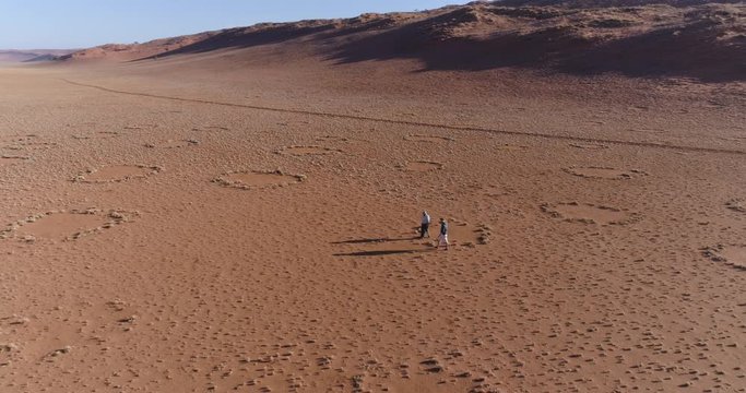 Aerial view of a tourist and guide exploring the famous fairy circles in the NamibRand Nature Reserve
