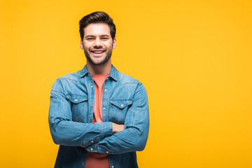 smiling good-looking man with crossed arms Isolated On yellow