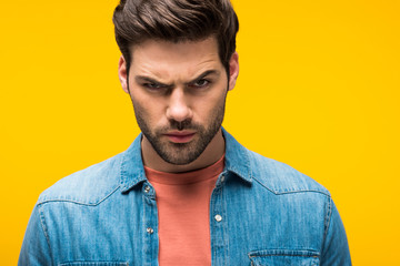 Obraz premium handsome aggressive man looking at camera Isolated On yellow