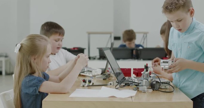 Curious kids working on a functional programable robot during robotics class at school. 4K UHD 60 FPS SLOW MOTION