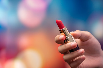 Closeup of woman hands rotates lipstick