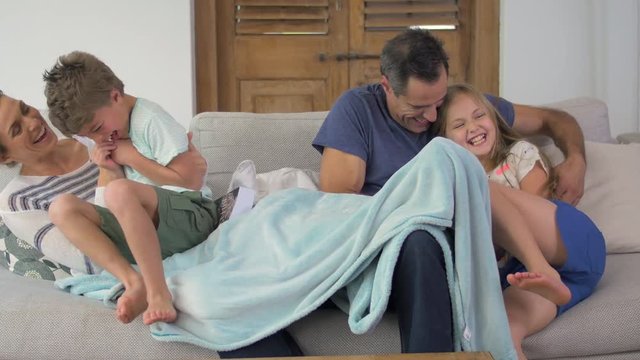 Children jumping onto couch