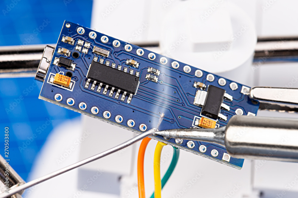 Aufkleber soldering pins and wires with iron tool of blue micro controller chip board circuit. electroncs serv