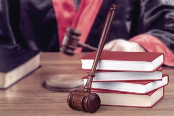 Male hands writing and wooden judge hammer on background