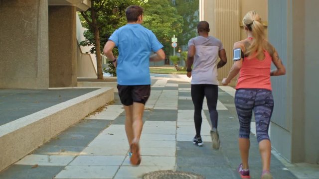 Fit healthy friends running between buildings