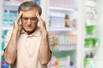 Mature man having headache on  background