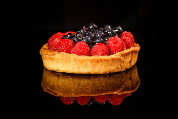 closeup shortbread mini tart with raspberries and blueberries