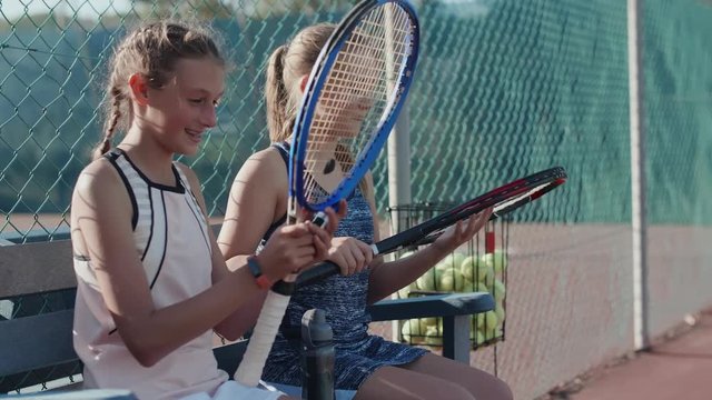 Young tennis players comparing rackets before training