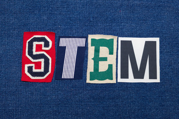 STEM text word collage, colorful fabric on blue denim, science technology engineering and mathematics, horizontal aspect