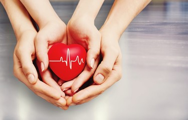 Man and woman holding red heart in