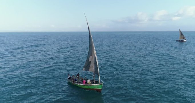 Aerial close-up view of two traditional dhow fishing boats heading out to sea for the days fishing