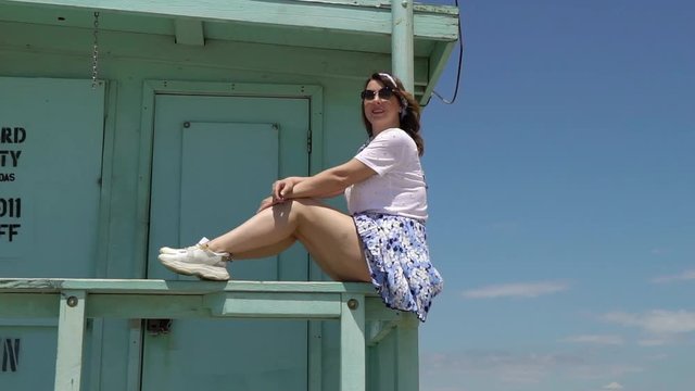 Young girl at the beach. Lifeguard booth