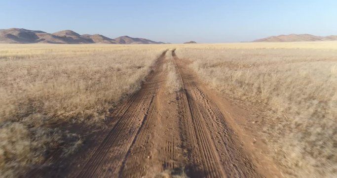 4K aerial close-up view of a sand road in the Koakoland savannah region of the Namib desert, Namibia