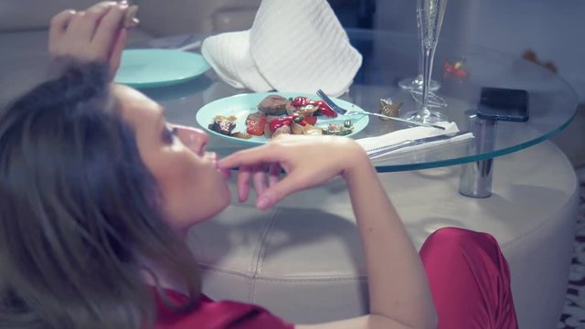 woman gets drunk at home alone at a table set for two for a romantic date, as her partner did not come on a date