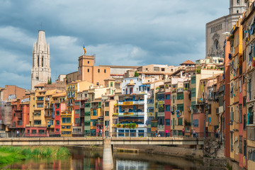 Collegiate Church of Sant Felix and multi colored houses from bridge on the Onyar River, Girona