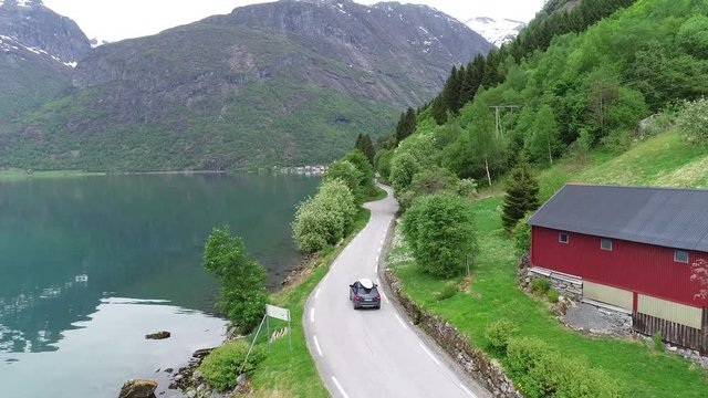 Car on driving road trip on picturesque Norwegian roads next to the fjord