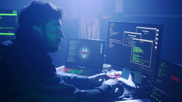 Close-up of computer hacker typing a code to break the server. Failing attempt of cyber crime in the company at night.