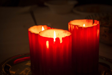 Three tall lit red candles